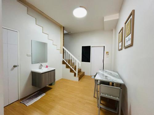 een kamer met een wastafel en een trap met een spiegel bij Sun sun house in Chiang Mai