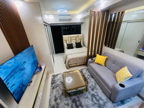 a living room with a couch and a bed at Modern Makati Condo with Balcony & Cityscape Views in Manila