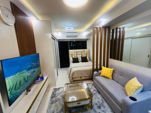 a living room with a couch and a bed at Modern Makati Condo with Balcony & Cityscape Views in Manila