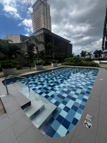 a large swimming pool with a building in the background at Modern Makati Condo with Balcony & Cityscape Views in Manila