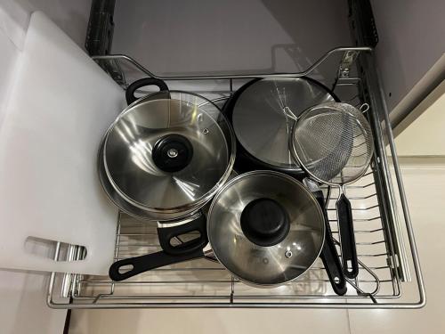 a drying rack with four pans and a strainer at Modern Makati Condo with Balcony & Cityscape Views in Manila