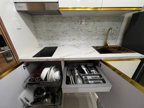 a small kitchen with a sink and a counter at Modern Makati Condo with Balcony & Cityscape Views in Manila