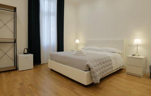 a bedroom with a large white bed with two lamps at Relais Vittorio Veneto - Luxotel & Apartotel in Salerno