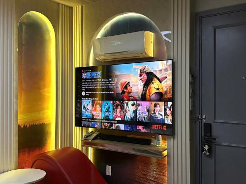 a flat screen tv sitting on top of a wall at Cupid Hotel in Ho Chi Minh City