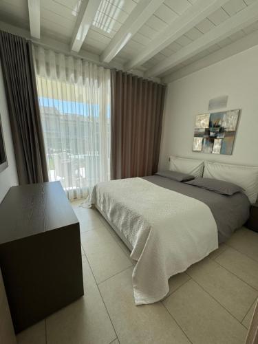a bedroom with a bed and a large window at De Luxe Apartments Eden in Sirmione