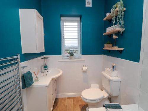 a blue bathroom with a toilet and a sink at The Old Chapel in Scarborough