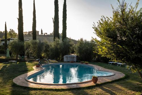een zwembad in een tuin met bomen bij Fonte del Salcio - Pool&Relax in Cinigiano