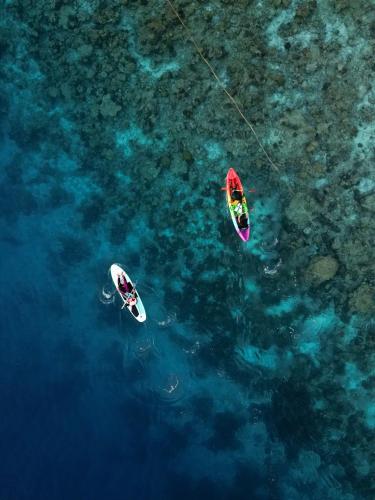two people on surfboards in the water at ARIA Beach, Ukulhas in Ukulhas