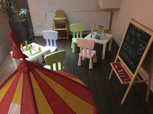a classroom with colorful chairs and tables and a chalkboard at Zajazd Pod Borem in Pokój