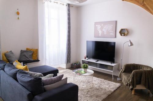 un salon avec un canapé bleu et une télévision dans l'établissement City center duplex loft, à Colmar