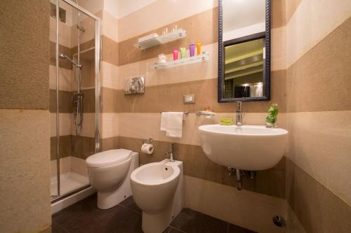 a bathroom with a sink and a toilet and a mirror at The Inn at the Spanish Steps Luxury Collection - The Inn at the Spanish Steps in Rome