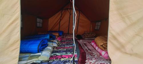 a tent with many blankets and pillows in it at Shivalik Adventure By StayApart in Kedārnāth