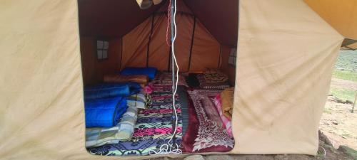 a tent with blankets and pillows in it at Shivalik Adventure By StayApart in Kedārnāth