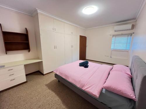 a bedroom with a bed with a pink blanket at 33 Room in Epping
