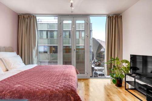 une chambre avec un lit et une grande fenêtre dans l'établissement City Center Apartment, à Tromsø