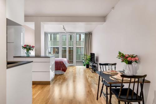 une cuisine et un salon avec une table et des chaises dans l'établissement City Center Apartment, à Tromsø