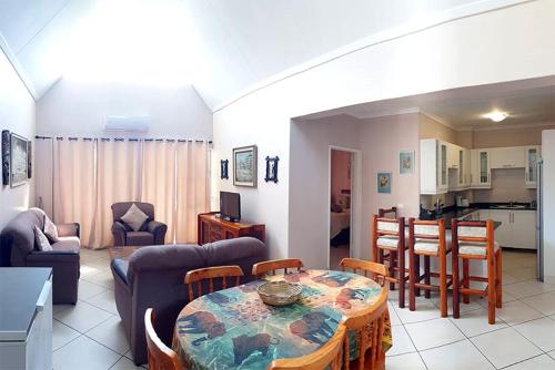a living room with a table and a kitchen at The Bridge Apartment, Unit 42 in St Lucia