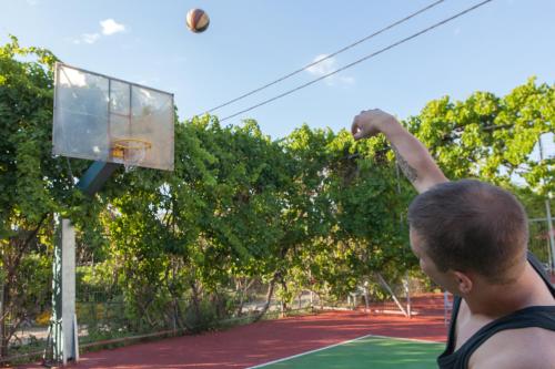 a man throwing a basketball into a hoop at Long Beach Hotel & Resort in Lóngos