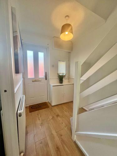 a white room with a staircase and a door at Stanley House in Stockton-on-Tees