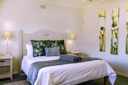 a bedroom with a large white bed and two lamps at The Mountainview Family Retreat in Hermanus