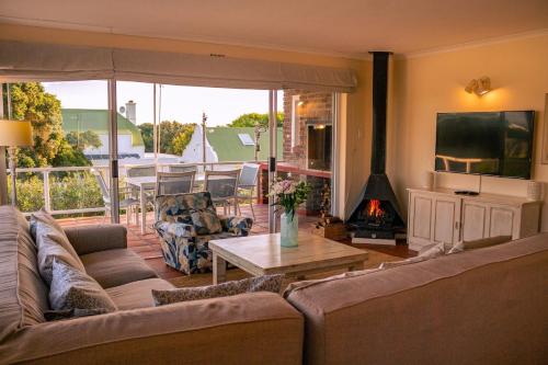 a living room with a couch and a table with a fireplace at The Mountainview Family Retreat in Hermanus