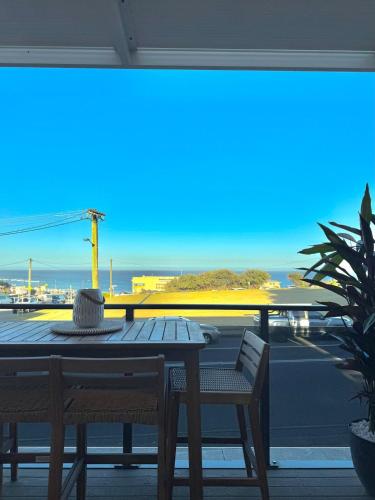 a table and chairs on a balcony with a view at Merewether By The Beaches Newcastle, Free Parking, Ocean View in Newcastle