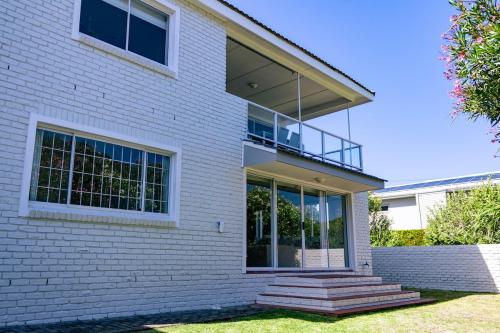 a white brick house with a balcony on it at The Mountainview Family Retreat in Hermanus
