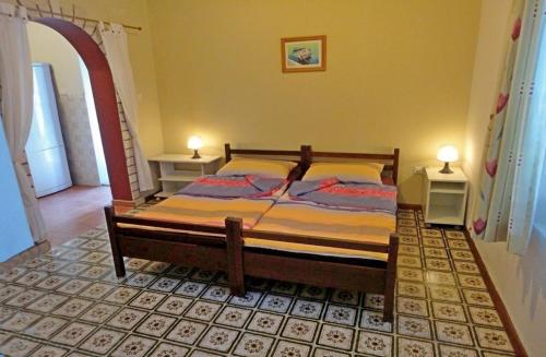 a bedroom with a bed with two tables and two lamps at Holiday House Vis Pavic in Vis