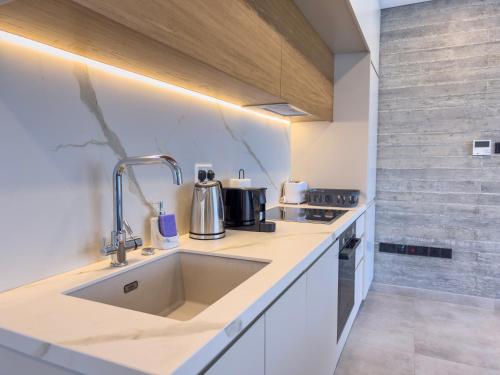 a kitchen with a sink and a stove at Malberry Park 201 - Modern 2 Bedroom Apartment with Pool, Gym, Jaccuzi in Paphos City