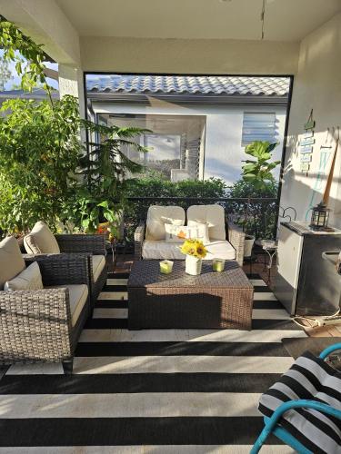 a patio with couches and a table with flowers on it at Peace and Quiet in North Port