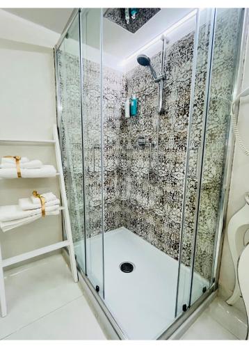 a shower with glass doors in a bathroom at Hotel La Torraccia in Tarquinia
