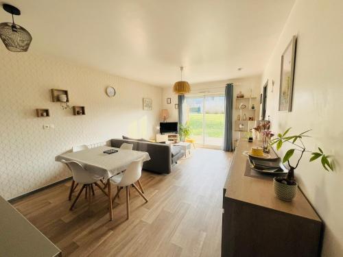 a living room with a table and a couch at Très bel appartement proche de la mer in Plestin-les-Grèves