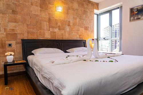 a bedroom with a large bed with white sheets at The Lofts on Wood Avenue in Nairobi