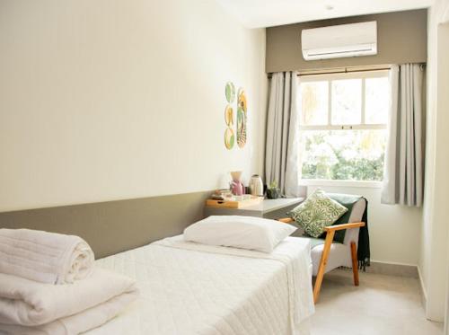 a bedroom with two beds and a window at Apart-hotel Cantinho da Serra in Nova Friburgo