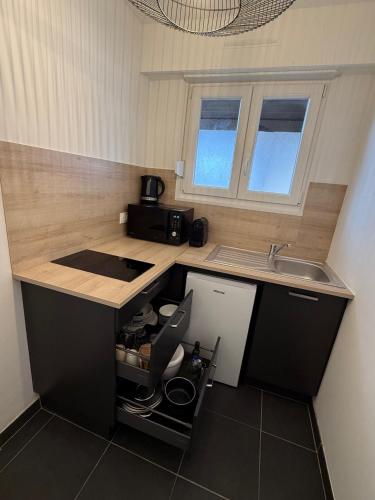 une cuisine avec un évier et un plan de travail dans l'établissement Appartement proche Strasbourg Centre 7 min gare, à Strasbourg