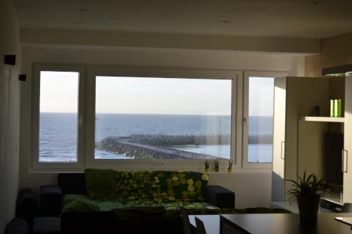 a living room with a large window looking out at the ocean at Studio 24 Oostende in Ostend