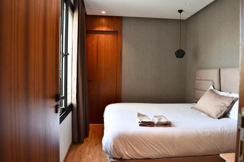 a bedroom with a bed with two shoes on it at Le Palmier - By Mi-Haven in Casablanca