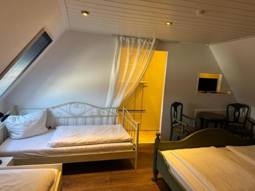 a small bedroom with two beds and a window at Zur schönen Rosenblüte, Ferienhaus in Schülern