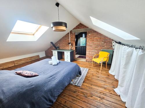 une chambre avec un lit et un mur de briques dans l'établissement La Belle Maison, centre ville, 3 chambres et jardin, à Reims