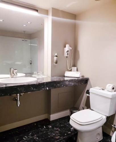 a bathroom with a toilet and a sink and a phone at The Lince Nordeste in Nordeste