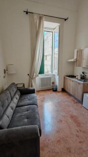 a living room with a couch and a large window at Dimora San Leucio in Lecce