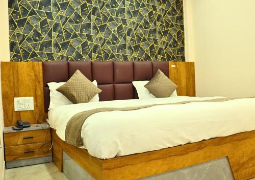 a bedroom with a large bed with a brown headboard at Ganga Riverfront Rooms And Banquet in Prayagraj