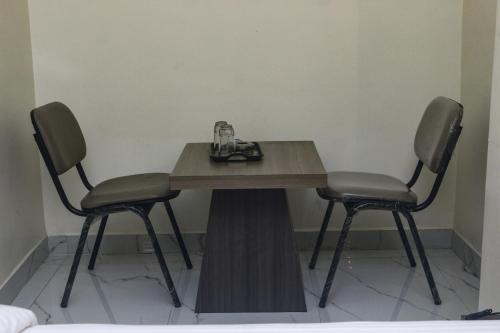 UlhāsnagarHotel Grace Lodging & Boarding的一张桌子和两张椅子