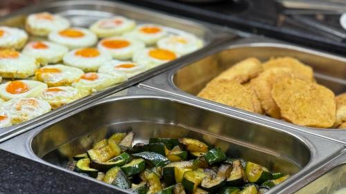 a buffet of food with eggs and vegetables in trays at Wellness Hotel Diplomat in Rajecké Teplice