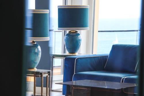 a living room with a blue couch and a lamp at Cala del Porto Punta Ala - Preferred Hotels in Punta Ala