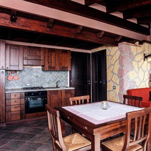 a kitchen with a wooden table with chairs and a stove at EdenRock in Riva dei Pini