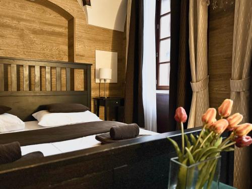 Un dormitorio con una cama y una mesa con un jarrón de flores. en Unique Prague Apartment, en Praga