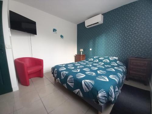 une chambre avec un lit et une chaise rouge dans l'établissement Aux Buzons, Jolie Villa champenoise, à Moslins