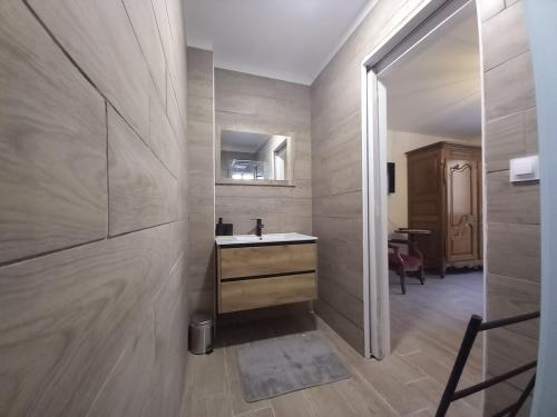 une salle de bain avec un lavabo et un miroir dans l'établissement Aux Buzons, Jolie Villa champenoise, à Moslins