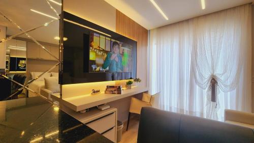 a living room with a tv and a couch and a window at Studio Pomerode in Pomerode